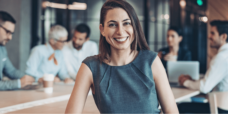 canva-woman-similing-team-meeting-in-background