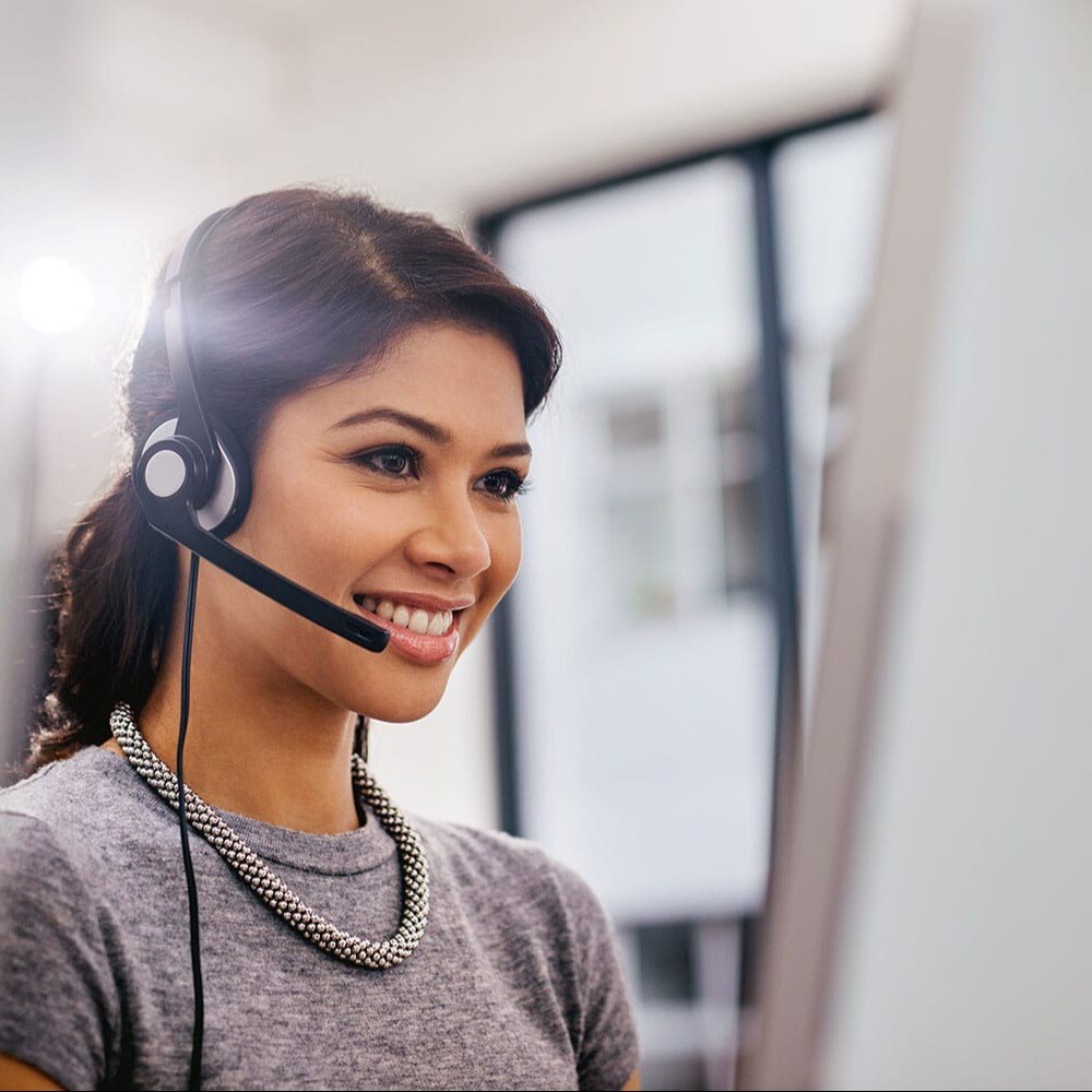 smiling-woman-behind-computer-on-headset